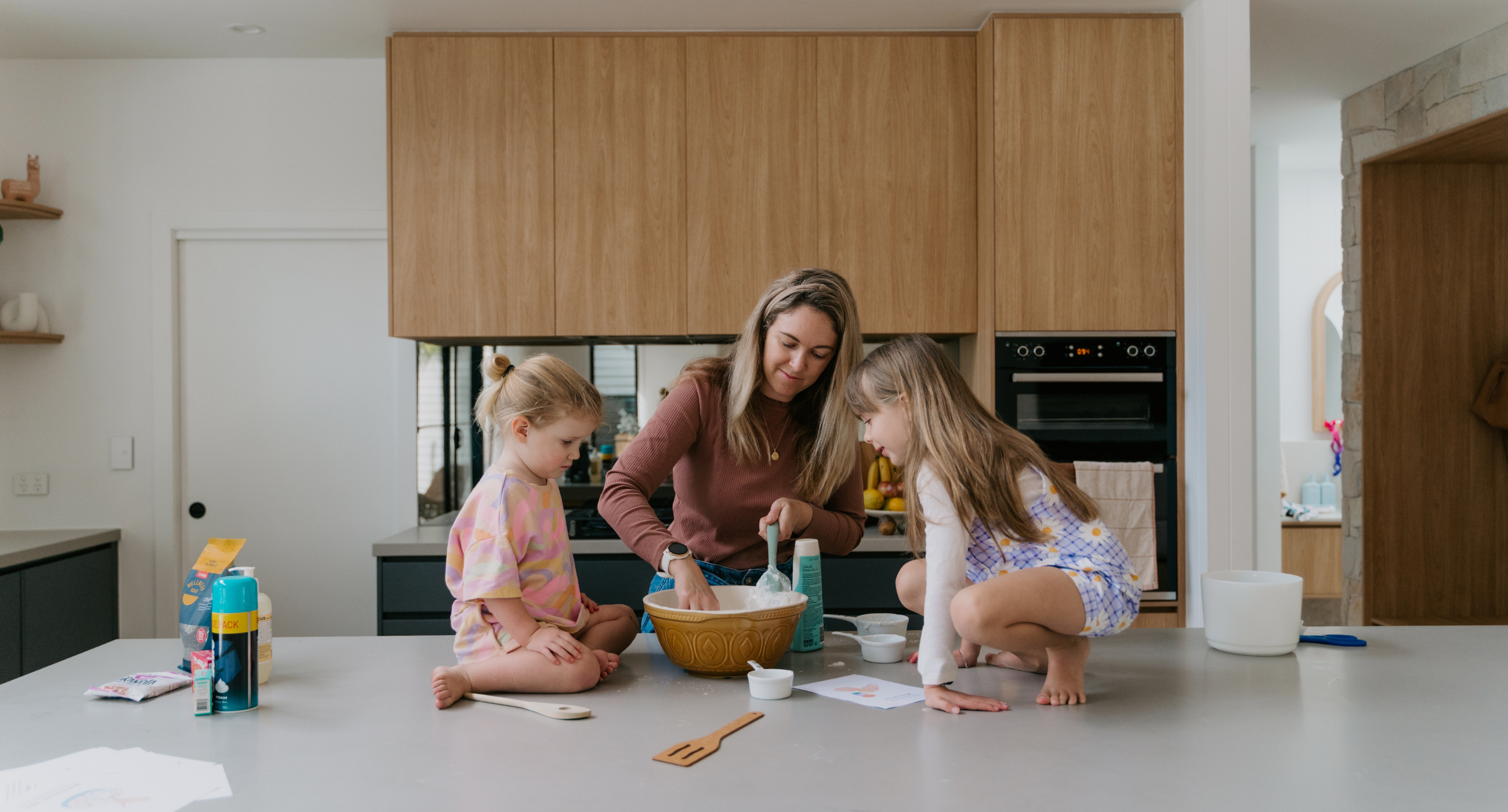 adult playing cooking tools with 2 kids