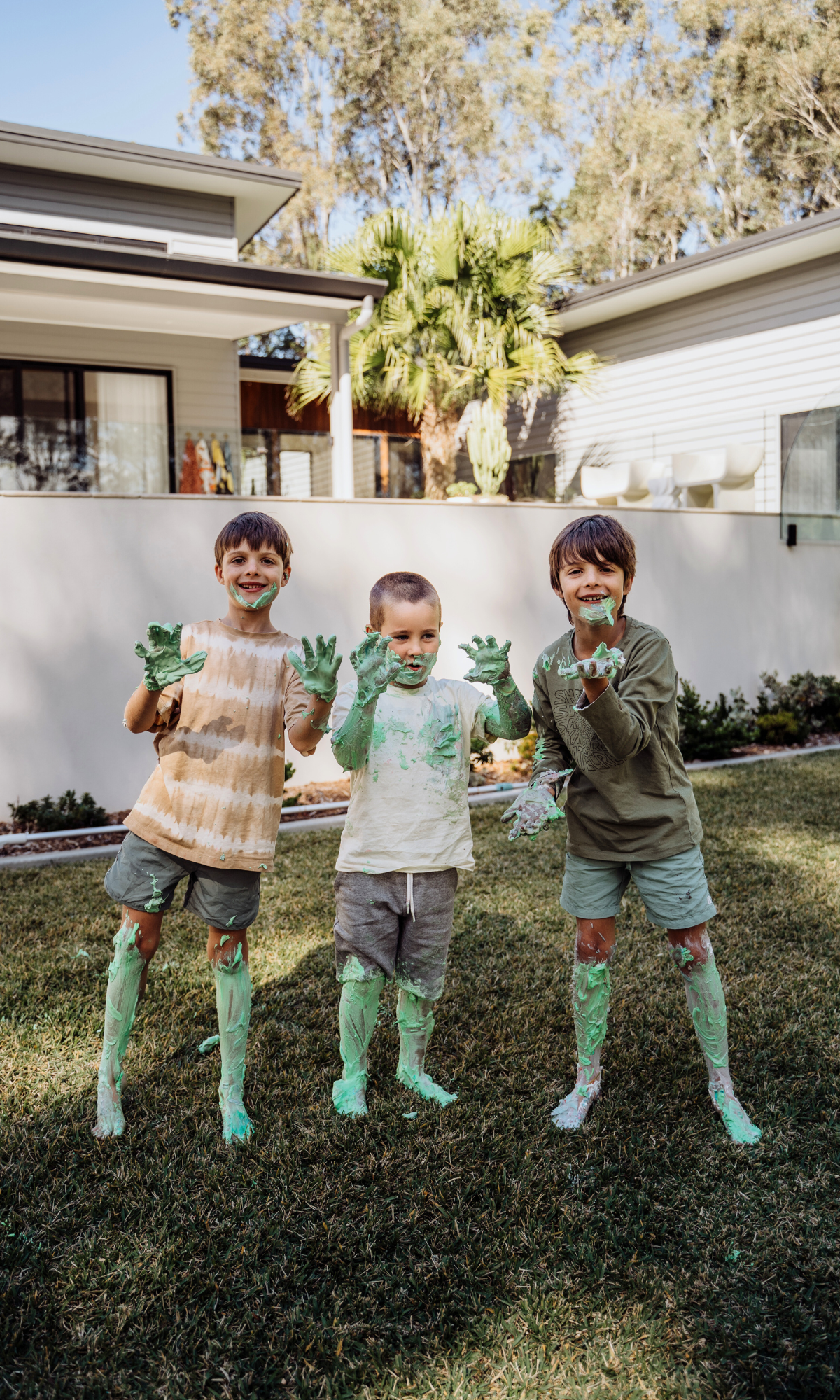 three kids playing in th yard