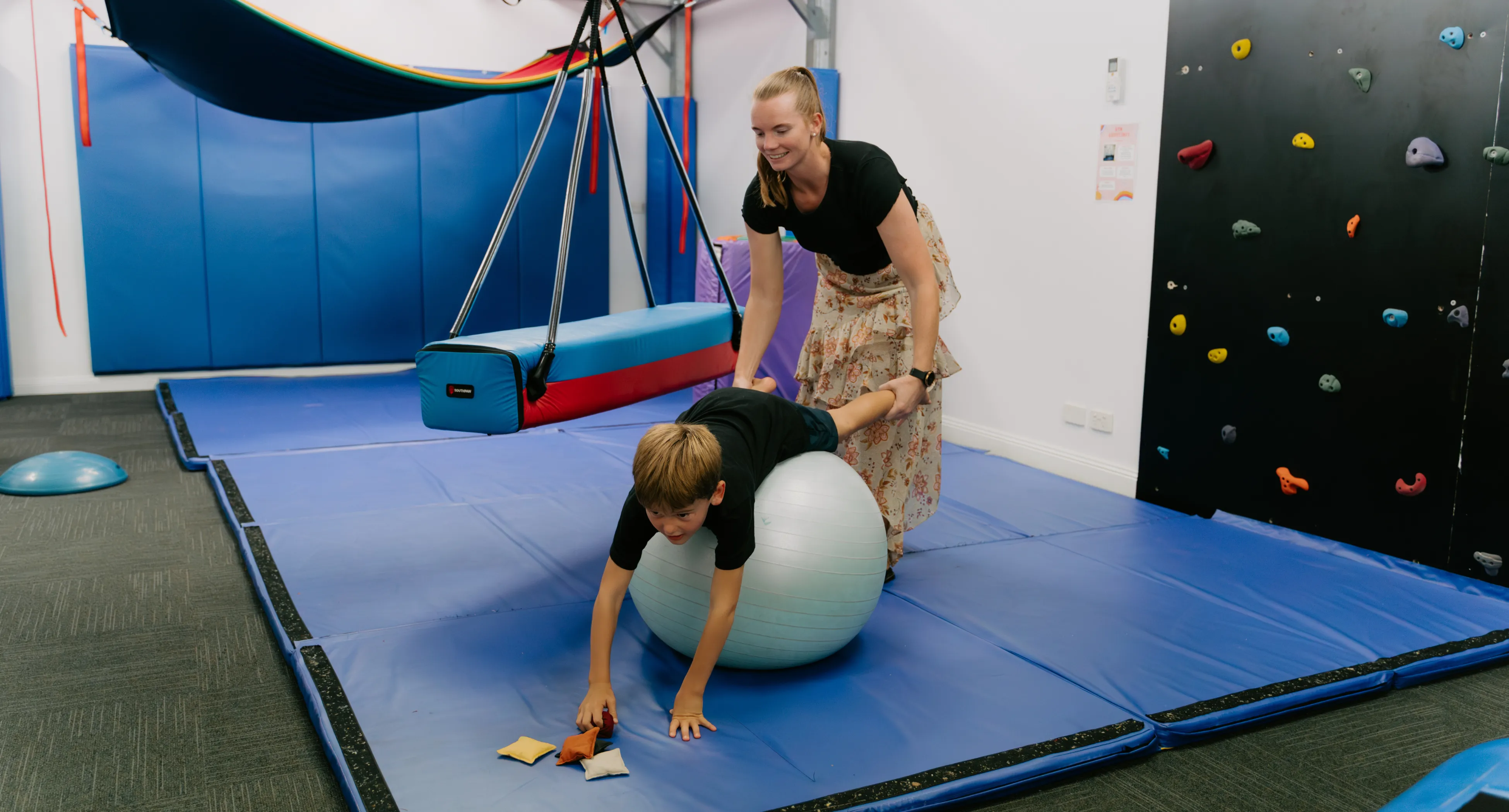 adult and kid play with a yoga ball